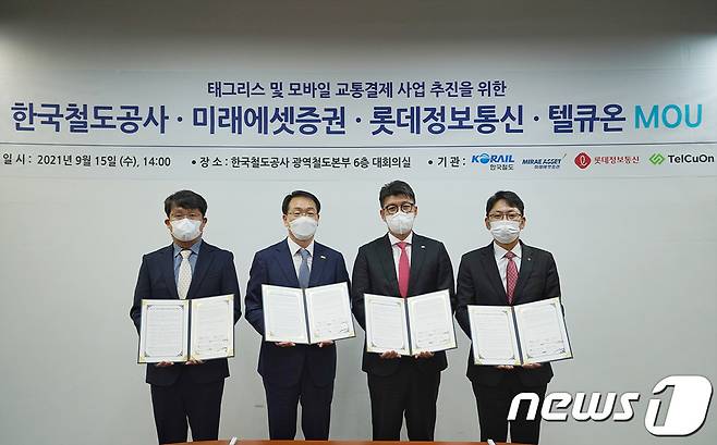 김승훈 텔큐온 대표이사(왼쪽부터), 김인호 한국철도 광역철도본부장, 안인성 미래에셋증권 디지털부문대표, 남환우 롯데정보통신 플랫폼사업본부장이 15일 비접촉식 교통요금 결제 시스템 개발을 위한 업무협약을 체결하고 협약서를 들어보이고 있다. (한국철도 제공) © 뉴스1