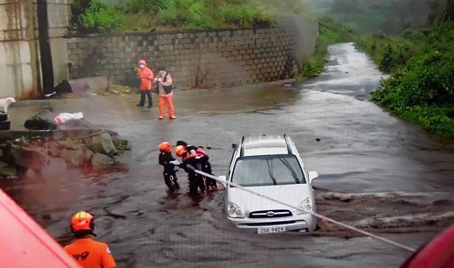 제주도소방안전본부 소속 119구조대가 14일 제주시 용강동 하천이 물이 불어나면서 고립된 차량에서 주민을 구조하고 있다./제주도 소방안전본부