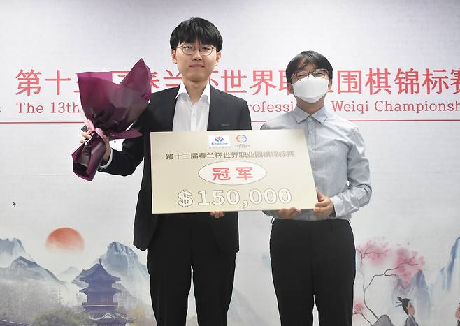 제13회 춘란배 우승 후 시상식에서 우승 트로피와 상금보드를 나란히 들고 선 신진서(왼쪽)와 목진석 대표팀 감독.   /한국기원