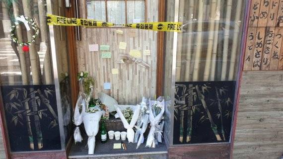 이달 초 서울 마포에서 맥줏집을 운영하던 50대 A씨가 코로나19로 인한 경영난 끝에 세상을 등진 가운데, A씨의 가게 앞에 추모 메시지와 국화, 소주병 등이 놓여 있다. 사진= 송주용 기자