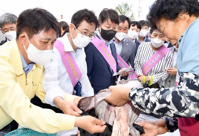 이철우 경북도지사(가운데)와 권영진 대구시장(오른쪽), 이희진 영덕군수(왼쪽)가 인근 초등학교 폐교 터에 컨테이너로 설치한 설치한 임시시장에서 제수용품을 구입하고 있다.(사진=경북도 제공) 2021.09.15.