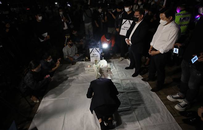 16일 오후 9시50분쯤, 서울 영등포구 여의도 국회의사당역 3번 출구 앞에서 자영업자들이 임시 분향소를 설치하고 생활고 끝에 극단적 선택을 한 동료 자영업자들을 추모하는 절을 하고 있다. /연합뉴스