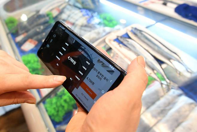 상인이 스마트오더 애플리케이션 꼼지락배송으로 소비자와 가격흥정을 하고 있다.