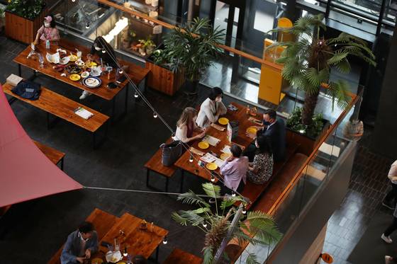 After new social distancing guidelines were announced on Sept. 6, five people eat lunch at the same table. The new rules allow six people, including two fully vaccinated, to have a private gathering. [WOO SANG-JO]