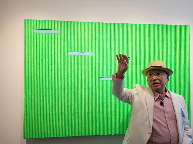 형광 연두색 색채 묘법 앞에 서 있는 박서보 화백.