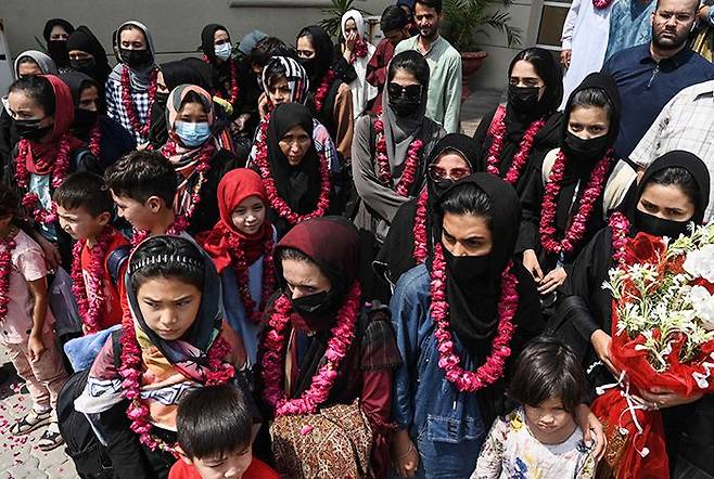 탈레반이 장악한 아프가니스탄에서 탈출한 국가대표 여자 청소년 축구팀 소속 선수와 가족, 코치 일행이 15일(현지 시각) 파키스탄 라호르에 있는 파키스탄축구협회(PFF) 본부 앞에 모여 있다. 이들은 아프간 수도 카불을 출발해 육로로 토르캄 국경지대를 거쳐 파키스탄으로 넘어왔다. /AFP 연합뉴스