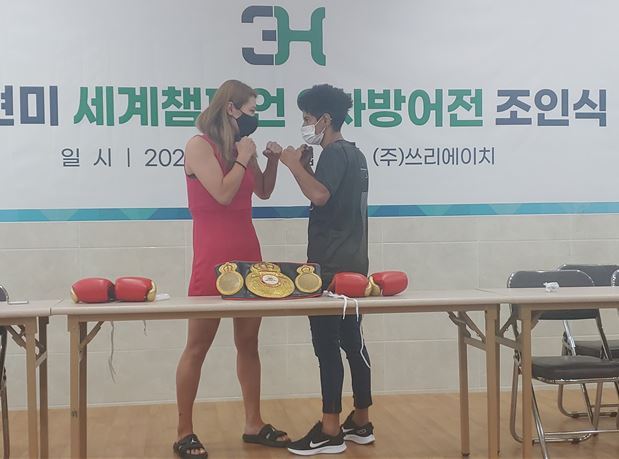 최현미(왼쪽)가 17일 서울 제기동 3H 강당에서 열린 WBA 슈퍼페더급 9차 방어전 조인식에서 도전자 시모네 다 실바와 주먹을 맞대고 있다.