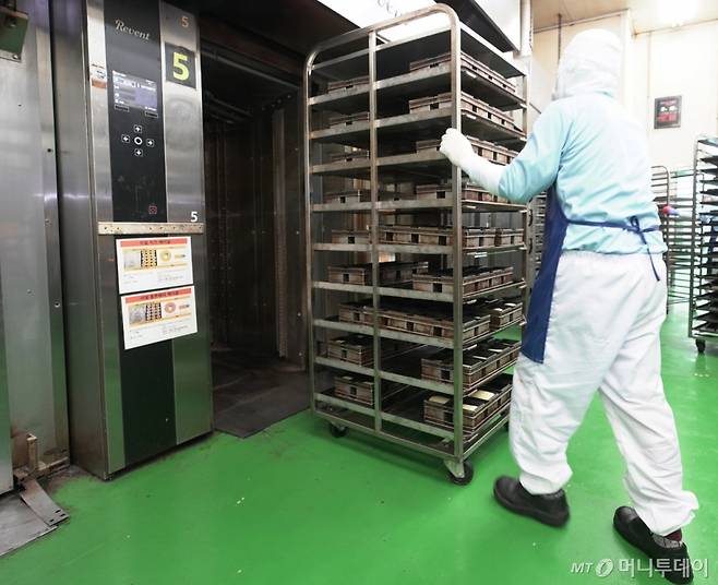 지난 10일 신세계푸드 천안공장 직원이 오븐으로 밀크앤허니 파베이크 식사빵 16결 데니쉬식빵을 옮기고 있다./사진제공=신세계푸드