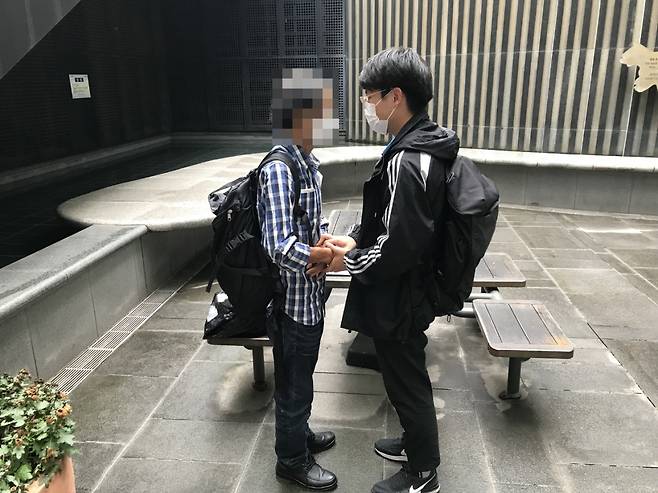 이용호 씨가 노숙인의 손을 잡은 채 대화를 나누고 있다. [이용호 씨 제공]