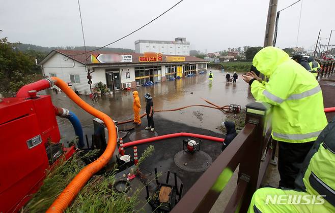 [제주=뉴시스] 우장호 기자 = 제14호 태풍 '찬투(CHANTHU)'가 제주를 통과한 17일 오전 제주시 용담2동에 위치한 상가 건물과 부지가 불어난 빗물에 침수돼 배수지원이 이뤄지고 있다. 2021.09.17. woo1223@newsis.com