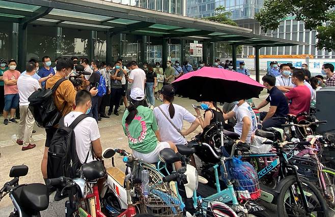 지난 15일 중국 광둥성 선전에 있는 대형 민간 부동산 개발업체 헝다(恒大·에버그란데) 그룹 본사 앞에 보안요원들이 배치된 가운데 투자자들이 몰려들어 돈을 돌려달라고 요구하고 있다. /연합뉴스