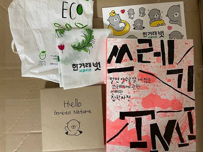 ‘겨리와 함께 줍깅’ 이벤트에 참여하면 제공되는 키트. <한겨레21> 기자들이 쓰고 친환경 재생용지로 인쇄한 <쓰레기TMI> 단행본, 생분해 쓰레기봉투, 겨리 손수건, 겨리 데코 스티커가 들어있다.