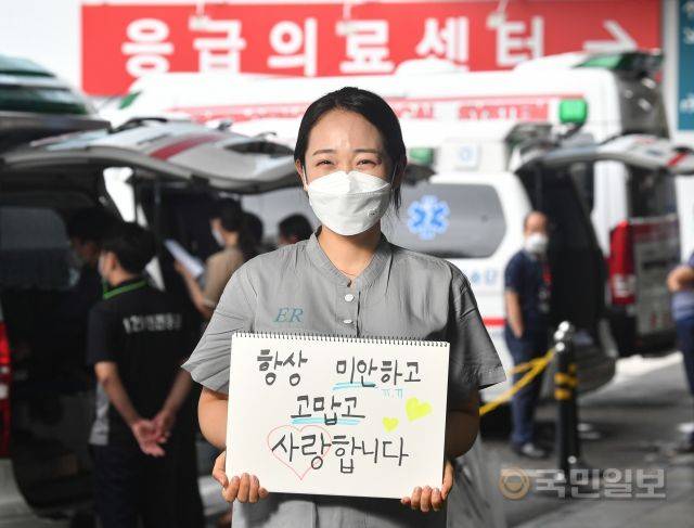 서울아산병원에서 근무 중인 이진주 간호사가 지난 7일 부모님에게 전달하는 메시지를 든 채 웃고 있다. 이 간호사는 "명절 음식 하는 것도 도와야 하는데 매번 혼자만 쏙 빠지는 것 같아 가족들에게 죄송한 마음이다"라고 말했다.