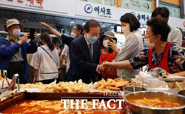 홍준표 국민의힘 대선 예비후보(가운데)가 19일 오후 서울 송파구 잠실 새마을 전통시장을 방문해 상인과 인사를 나누고 있다./홍준표 캠프 제공