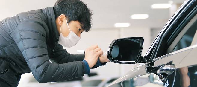KB캐피탈 소속 진단 전문가가 중고차 매매단지를 방문해 판매 차량을 살펴보고 있다. / KB캐피탈 제공