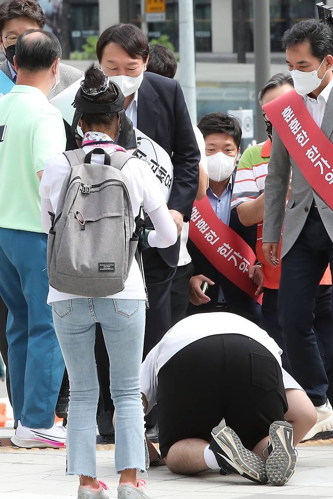 국민의힘 대통령선거 경선 후보인 윤석열 전 검찰총장이 한가위 연휴 둘째날인 19일 서울역에서 만난 귀성객의 큰절에 고개를 숙여 답하고 있다. 뉴스1