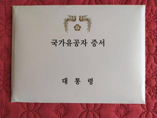 국가유공자 증서  (서울=연합뉴스) 잘못된 병적 기록으로 참전유공자로 인정받지 못했던 황모씨의 아들이 국민권익위의 병적 기록 정정 요구로  아버지의 국가유공자 증서를 받게 되자 감사를 전하며 보내온 사진. 2021.9.20. [국민권익위원회 제공. DB 및 재판매 금지]