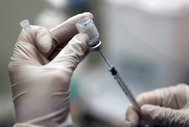 서울 동작구 예방접종센터에서 의료진이 백신을 주사기에 주입하고 있다/ 뉴시스