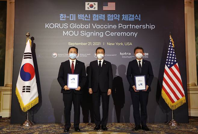 문재인 대통령이 21일(현지시간) 미국 뉴욕 JW메리어트 호텔에서 열린 한미 백신 협력 협약 체결식에서 MOU 체결 후 기념사진을 촬영하고 있다. 왼쪽부터 찰스 리 잭슨연구소 유전체의학 연구소장, 문 대통령, 성제경 국가마우스표현형사업단장. 뉴욕｜연합뉴스