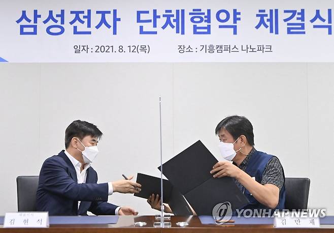 삼성전자 노사 첫 단체협약 (용인=연합뉴스) 지난달 12일 경기도 용인시 삼성전자 기흥캠퍼스 나노파크에서 열린 단체협약 체결식에서 김현석 삼성전자 대표이사(왼쪽)와 김만재 대표교섭위원이 협약서를 교환하고 있다. [연합뉴스 자료사진]