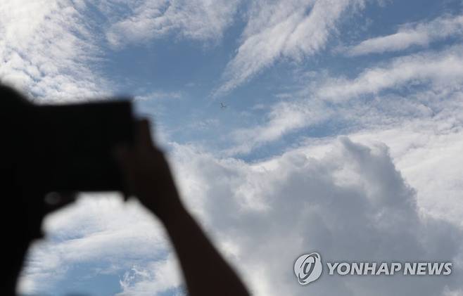 구름 많은 날씨 구름 많은 날씨를 보인 지난 8일 오후 경남 김해시청 인근에서 한 시민이 휴대 전화로 하늘을 촬영하고 있다. [연합뉴스 자료사진]