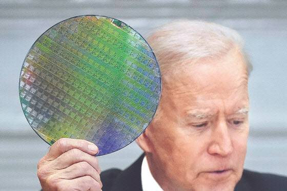 조 바이든 미국 대통령이 지난 4월 백악관에서 열린 ‘반도체 CEO 서밋’에 참석해 반도체 실리콘 웨이퍼를 들어올리며 반도체 관련 업체에 미국 내 투자를 강조했다. (사진=AP통신)