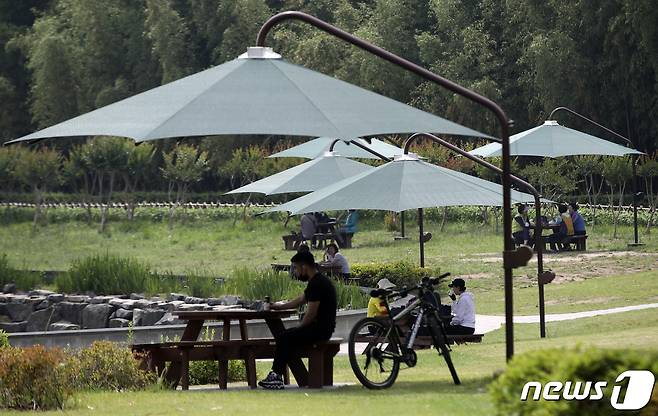 울산 태화강 국가정원 오산못 분수대를 찾은 시민들이 그늘막 아래에서 휴식을 취하고 있다. 2021.6.2/뉴스1 © News1 윤일지 기자