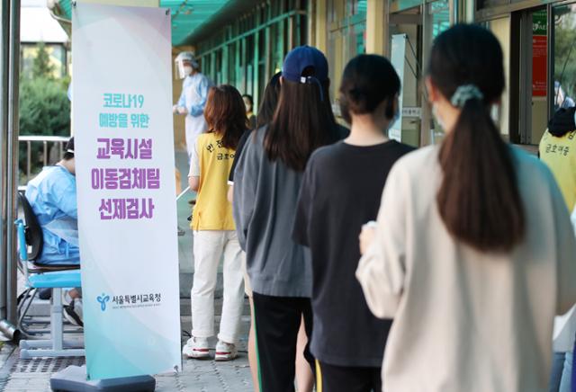 23일 오전 서울 중구 금호여중에 추석 연휴 이후 학생 확진자 확산을 막기 위해 마련된 이동식 PCR 검사소에서 학생과 교직원들이 검사를 받기 위해 줄지어 기다리고 있다. 뉴스1