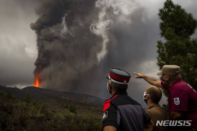 [라팔마=AP/뉴시스] 스페인 카나리아제도 라팔마섬 쿰브레 비에호 화산 폭발 현장 인근에서 22일(현지시간) 현지 경찰과 구조대가 용암을 살피고 있다. 2021.09.23.