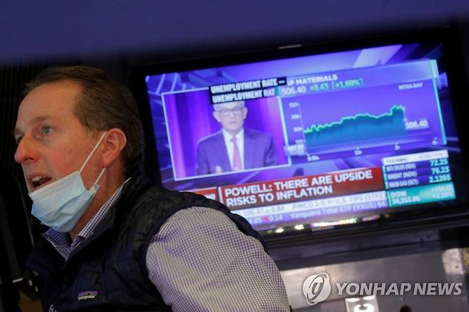 제롬 파월 연준 의장의 회견을 중계하는 TV 앞에서 근무 중인 뉴욕증시 트레이더 [로이터=ㅇ녀합뉴스]