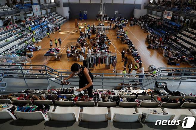 23일(현지시간) 자원봉사자들이 스페인 카나리아제도 라팔마 섬의 쿰브레 비에호 화산 폭발로 집을 잃은 사람들을 돕기 위해 세베로 로드리게스 체육관에서 기증품을 분류하고 있다. © 로이터=뉴스1 © News1 금준혁 기자