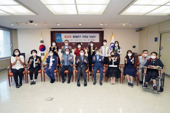 유덕열 동대문구청장(앞줄 가운데)과 14명의 구민상 수상자가   24일 동대문구청에서 열린 제30회 동대문구 구민상 시상식에서 기념촬영을 하고 있다