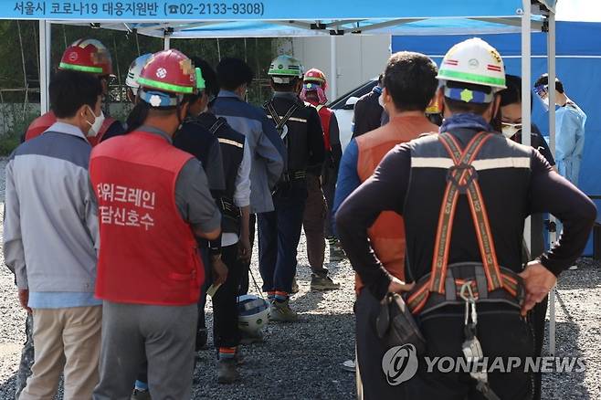 코로나19 검사 기다리는 작업자들 (서울=연합뉴스) 류영석 기자 = 신종 코로나바이러스 감염증(코로나19) 신규 확진자가 2천434명을 기록하며 하루 최다 확진자 수를 경신한 24일 오전 서울 강남구의 한 건설 현장에 마련된 '서울시 찾아가는 선별진료소'에서 작업자들이 코로나19 검사를 받기 위해 줄을 서 있다. 2021.9.24 ondol@yna.co.kr