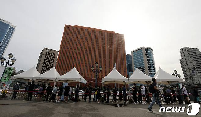 25일 오전 서울 서울역광장에 마련된 중구 선별검사소에서 시민들이 코로나19 검사를 받기위해 줄을 서서 기다리고 있다. /뉴스1