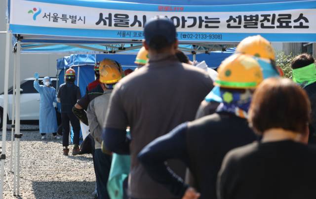 코로나19 신규 확진자가 2,434명을 기록하며 하루 최다 확진자 수를 경신한 24일 오전 서울 강남구의 한 건설 현장에 마련된 '서울시 찾아가는 선별진료소'에서 작업자들이 코로나19 검사를 받기 위해 줄을 서 있다./연합뉴스
