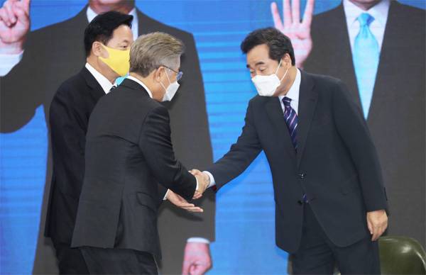 26일 오후 전북 완주군 우석대학교 체육관에서 열린 더불어민주당 전북 합동연설회에서 이재명 후보(가운데)와 이낙연 후보(오른쪽)가 악수하고 있다. 왼쪽은 이날 후보직을 사퇴한 김두관 후보.  [사진 출처 = 연합뉴스]