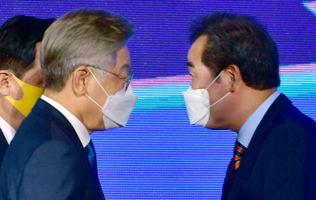 더불어민주당 대통령선거 후보자 선출을 위한 광주·전남 합동연설회가 열린 25일 오후 광주 서구 김대중컨벤션센터에서 득표 결과 발표 직후 이재명(왼쪽) 경지지사와 이낙연 전 대표가 엇갈려 지나고 있다. /연합뉴스