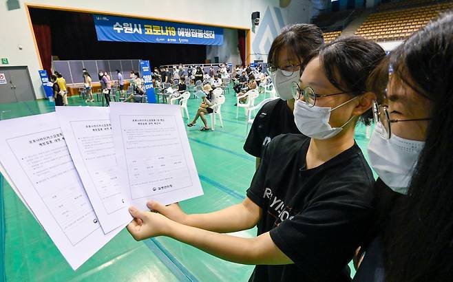 고등학교 3학년 학생 및 교직원 등에 대한 백신 접종이 시작된 19일 오전 경기도 수원시 영통구 아주대학교 체육관에 설치된 수원시 코로나19 예방접종센터에서 백신 접종을 마친 고3 학생들이 접종 확인서를 보여주고 있다./연합뉴스