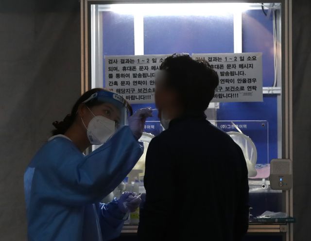 지난 26일 저녁 서울 강남역 '서울시&강남구 찾아가는 코로나19 선별진료소'에서 의료인이 시민의 코로나19 검사를 하고 있다. 뉴시스