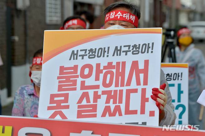 [광주=뉴시스] 변재훈 기자 = 광주 농성·화정동 침수 피해 주민대책위(주민대책위) 소속 주민들이 27일 광주 서구 농성동 상습 침수 주택가에서 항구적 수해 예방 대책을 촉구하는 기자회견을 열고 있다. 이들은 이어 침수 주택가부터 부터 서구청 광장까지 1.2㎞를 5보1배 형식으로 걷는 오체투지 행진을 벌였다. 2021.09.27. wisdom21@newsis.com