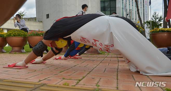 [광주=뉴시스] 변재훈 기자 = 광주 농성·화정동 침수 피해 주민대책위(주민대책위) 소속 주민들이 27일 광주 서구청 앞에서 5보1배 형식으로 걷는 오체투지 행진을 벌이고 있다. 이들은 화정동 서석고 주변 상습 침수 주택가부터 서구청 광장까지 1.2㎞를 행진 투쟁을 벌였다. 2021.09.27. wisdom21@newsis.com