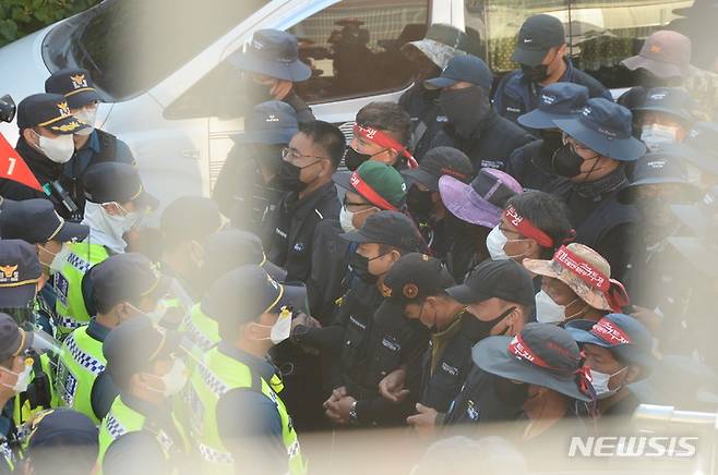 [청주=뉴시스] 조성현 기자 = 민주노총 화물연대 노조원들이 24일 오전 충북 청주시 흥덕구 송정동 SPC삼립 공장 앞에서 물류배송 차량의 진입을 막아서며 경찰과 대치하고 있다. 2021.09.24. jsh0128@newsis.com