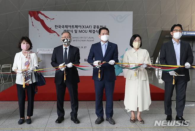[인천공항=뉴시스] 박미소 기자 = 김경욱(오른쪽 세번째) 인천국제공항공사 사장과 황달성 한국화랑협회장을 비롯한 참석자들이 27일 오후 인천국제공항 1터미널 교통센터에서 열린 한국국제아트페어(KIAF) 특별 전시 'We connect, Art & Future / KIAF and INCHEON AIRPORT' 개막식에서 테이프 커팅식을 하고 있다. 2021.09.27. misocamera@newsis.com