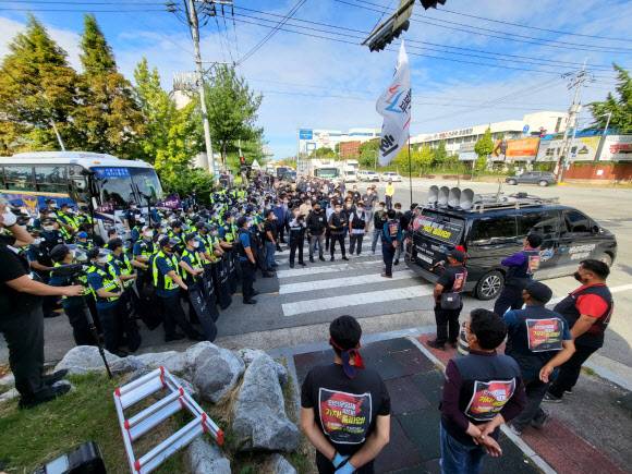 전국민주노동조합총연맹 화물연대본부 조합원들이 27일 충북 청주시 흥덕구에 있는 SPC 삼립 청주공장 앞 도로에서 경찰과 대치하고 있다. 화물연대는 전날 세종공장에서 결의대회를 하다 강제해산 당하자 이날 청주공장에 모여 철야 농성을 벌였다.청주 연합뉴스