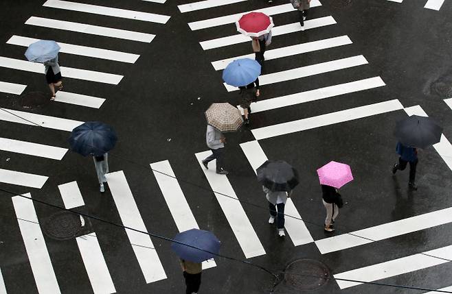 굵은 빗방울을 뿌리는 비구름이 해를 가려 잔뜩 흐린 날씨를 보인 지난 7일 오전 서울 중구 거리에서 우산을 쓴 시민들이 길을 걷고 있다. [사진출처 = 연합뉴스]
