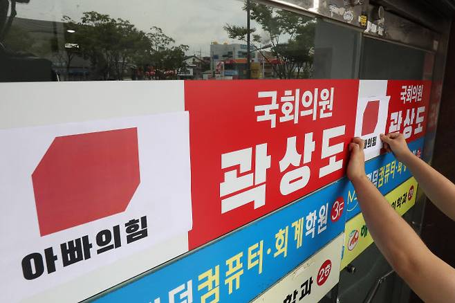 29일 오전 대구경북대학생진보연합 회원들이 아들의 퇴직금 50억 원 논란으로 국민의힘을 탈당한 대구 남구 곽상도 의원 지역구 사무실 앞에서 국회의원 사퇴요구 기자회견을 마친 뒤 국민의힘 당 로고 위에 ‘아빠의힘’이라고 쓰여진 로고를 붙이고 있다 (사진=뉴스1)