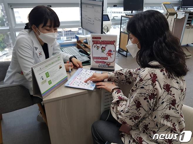 29일 한국건협 울산시지부 직원이 병원을 내원한 고객에게 심장질환 관련 예방법을 설명하고 있다.(한국건협 울산시지부 제공) © 뉴스1