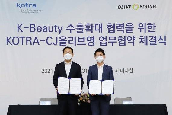 정윤규 CJ올리브영 경영지원담당 상무(오른쪽)와 김상묵 KOTRA 혁신성장본부장이 협약식을 마친 뒤 기념 촬영을 하고 있다. 올리브영 제공