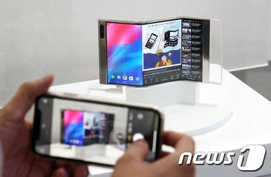 지난 달 서울 코엑스에서 열린 한국디스플레이산업 전시회에서 관람객들이 삼성디스플레이 부스에 전시된 '플렉스인앤아웃'을 둘러보고 있다. S자로 두 번 접는 형태다. [뉴스1]