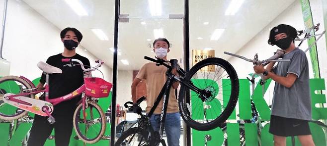 광주 방치자전거 재사용센터에서 자전거를 수리하는 청소년들이 29일 센터에서 수리 중인 자전거를 들어보이고 있다.